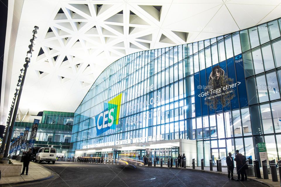 Las Vegas, NV, USA 1-6-2023: Exterior of Convention Center West Hall during CES2023. Logo of CES on glass wall. Light trails from car headlights of traffic passing by. Captured in long exposure.