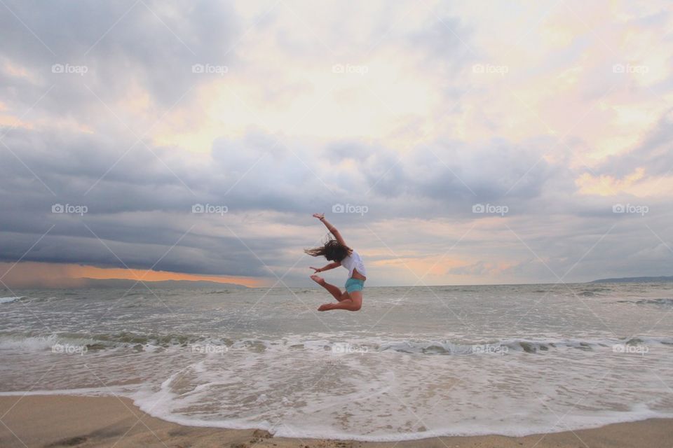 Girl jumps at the beach