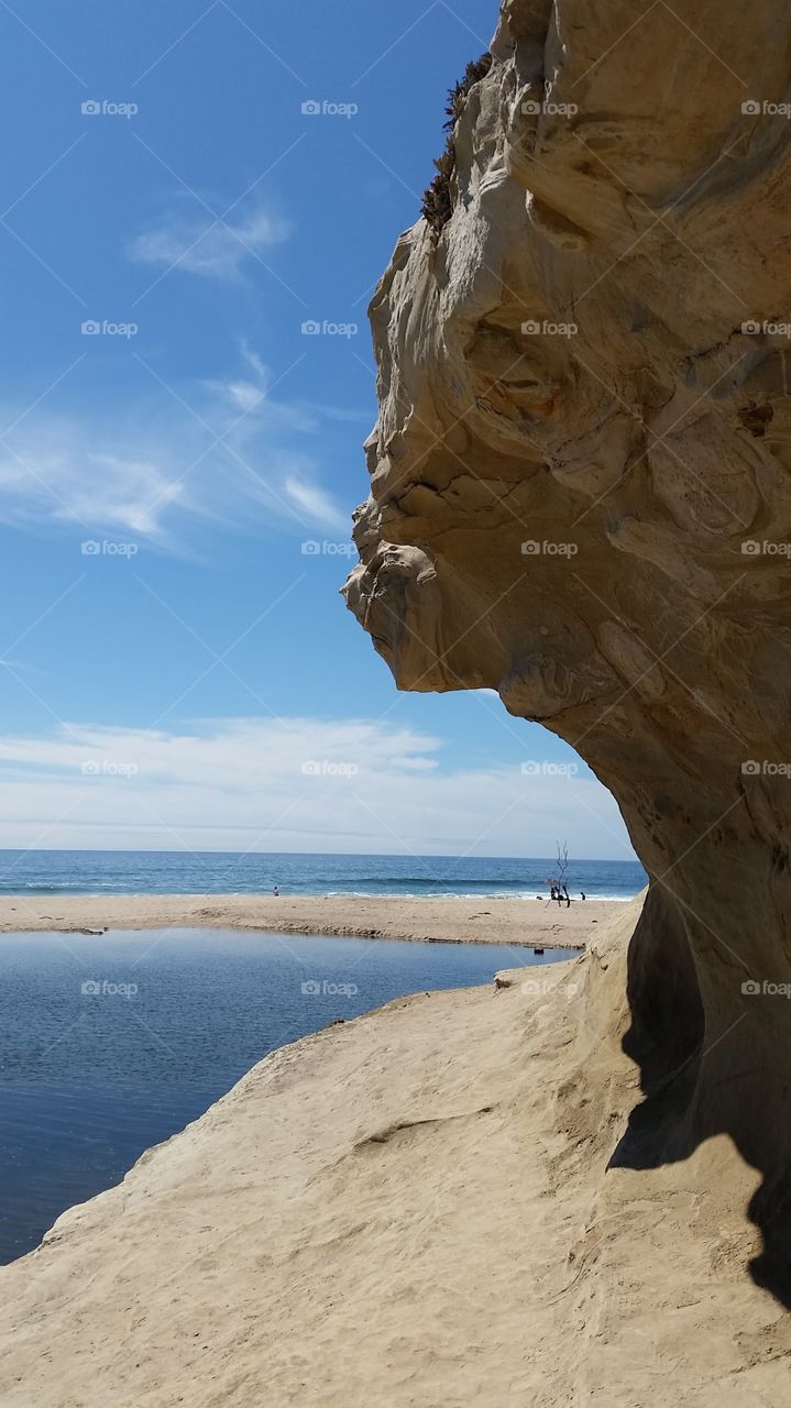 Rocky structure on the beach. Sandstone outcropping and lagoon on a beach