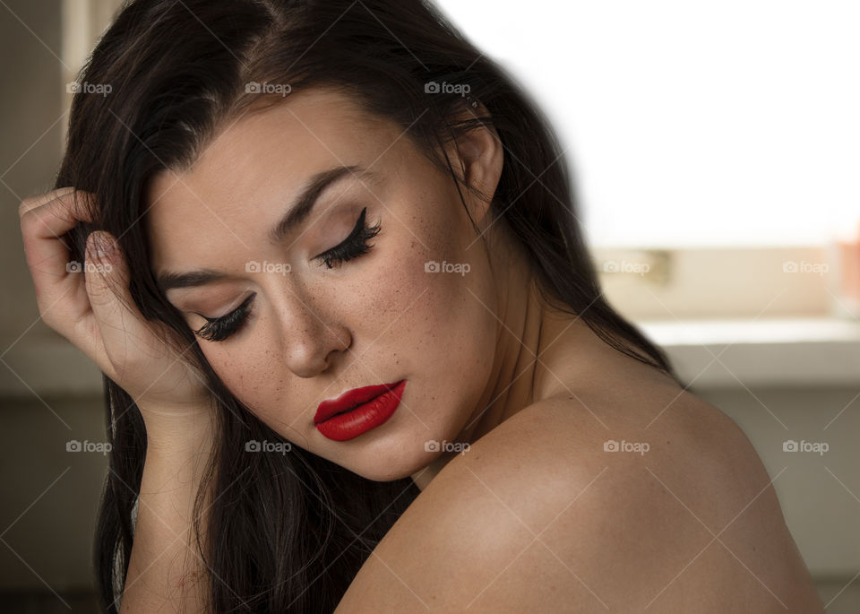 Portrait of a brunette girl with Ted lipstick and freckles. 