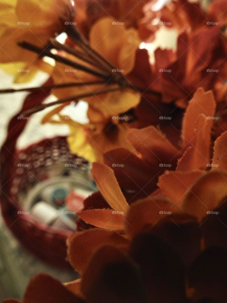 Orange yellow bouquet representing fall autumn in front of a woven dark red basket perfect for autumn fall days to warm up with hot chocolate keurig cups.