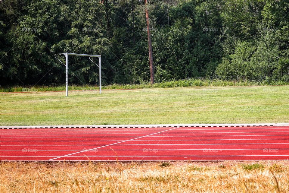 A sports field with a soccer goal and a running track