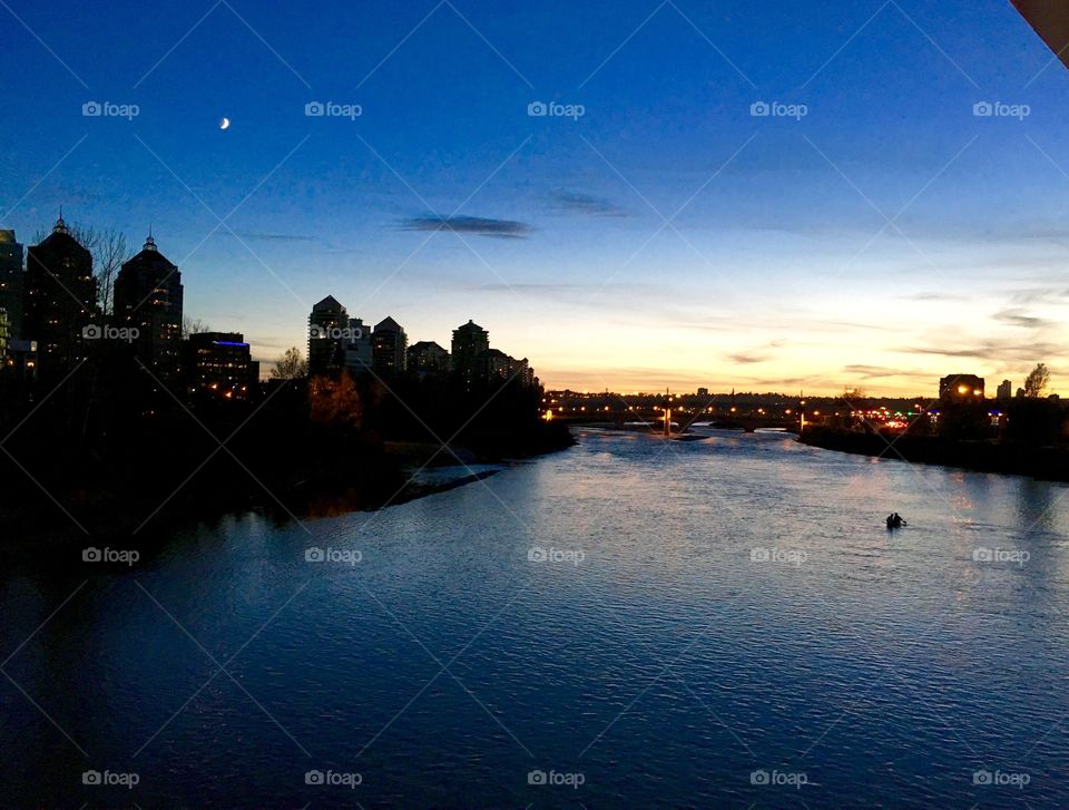 Sunset on the bow river. Sunset with the crescent moon over the river