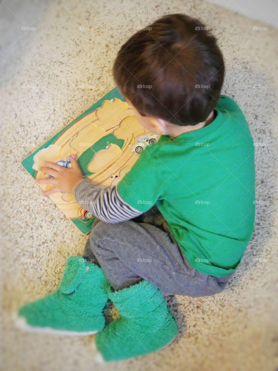 young child working on a wooden puzzle