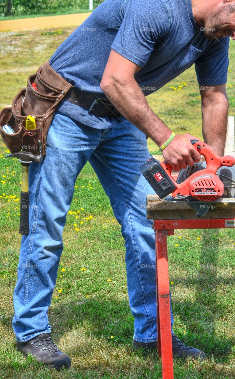 A very attractive man using a saw