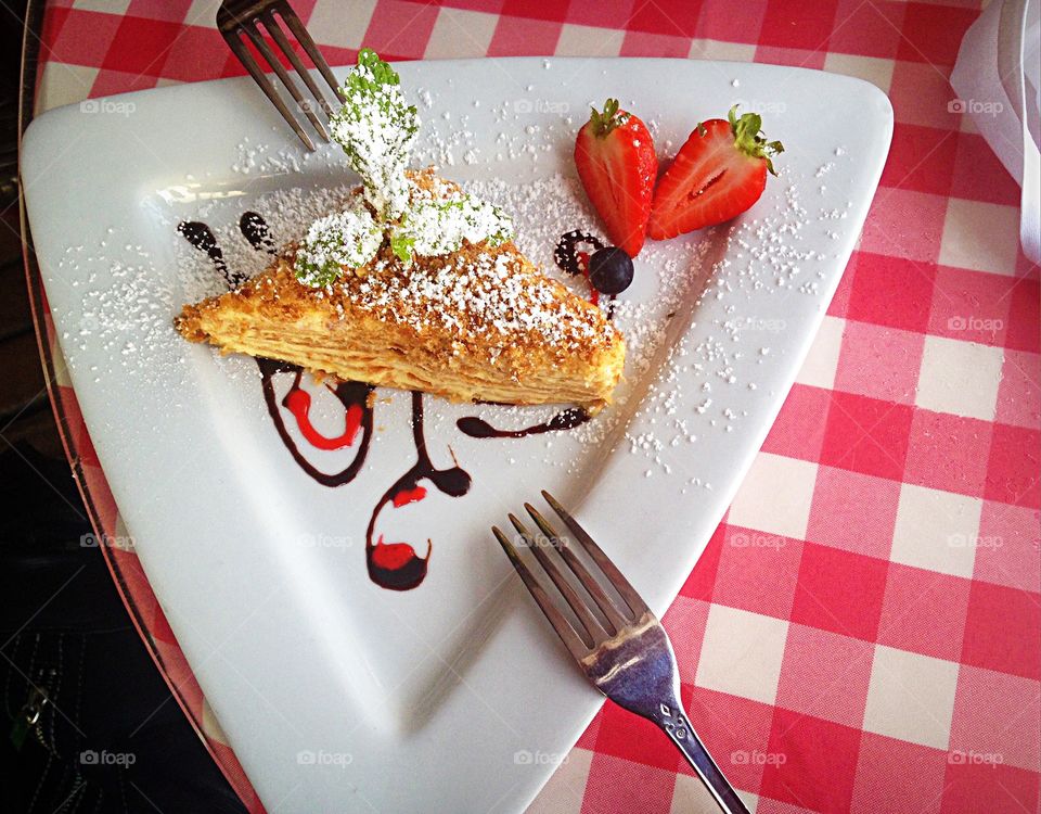 Napoleon dessert on a red and white checkered tablecloth.