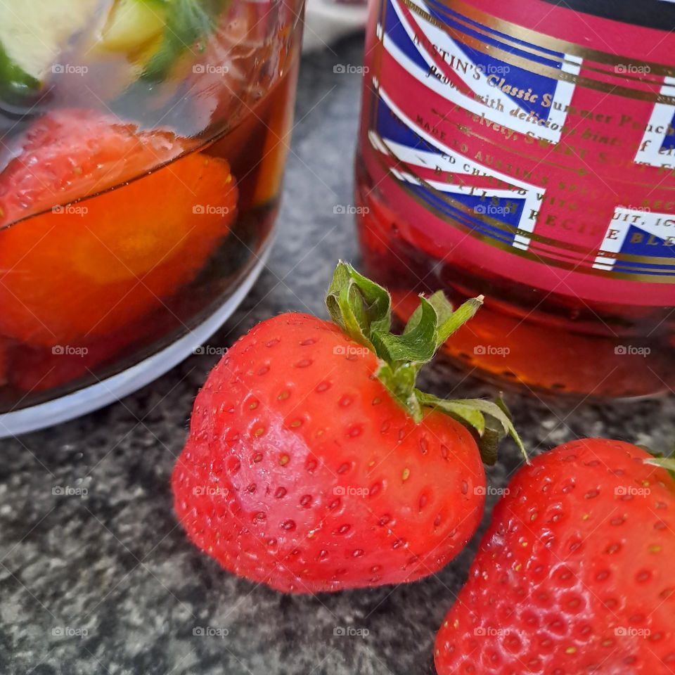 fruit, strawberries marinading in alcohol. pimms. british flag as a symbol on a bottle union jack