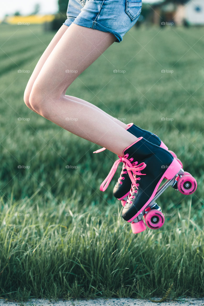 Teenage smiling happy girls having fun rollerskating, jumping, spending time together on summer day. Teenage smiling happy girls having fun walking outdoors, hanging, spending time together on summer day. Real people, authentic situations