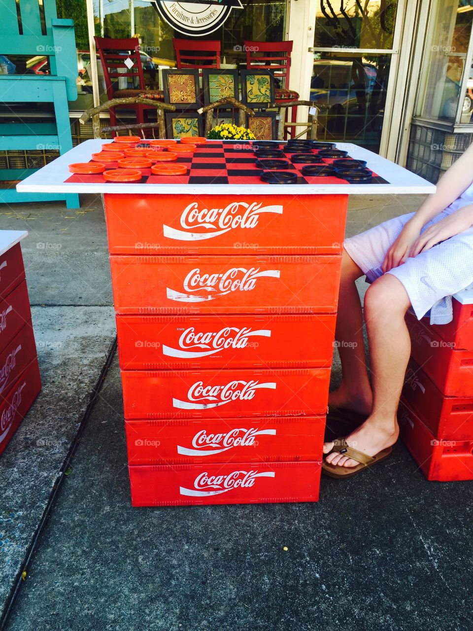 Sidewalk store front checkers game with teen Coca Cola