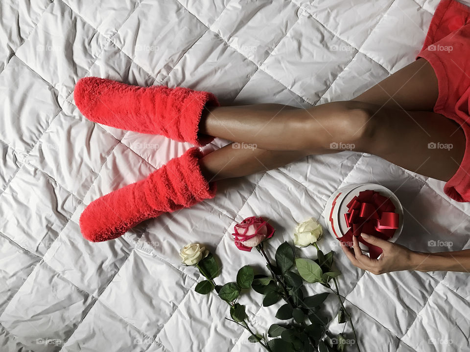 Gift box and flowers in bed 