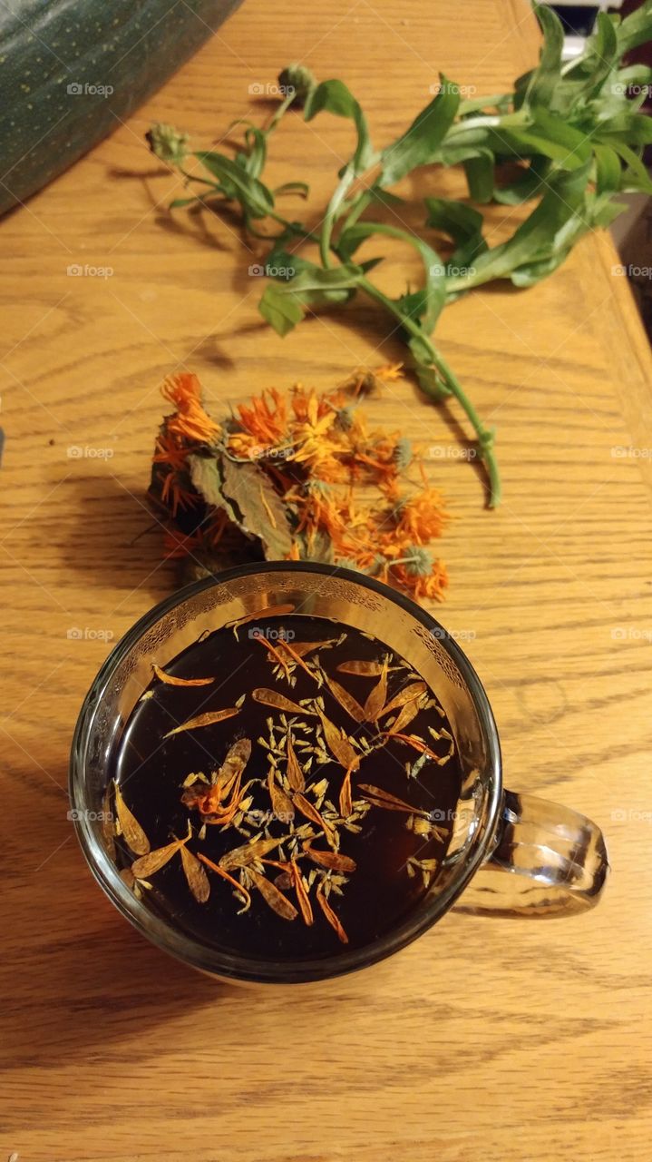 Herbal Tea on a Table with Marigolds and Spiky Lettuce