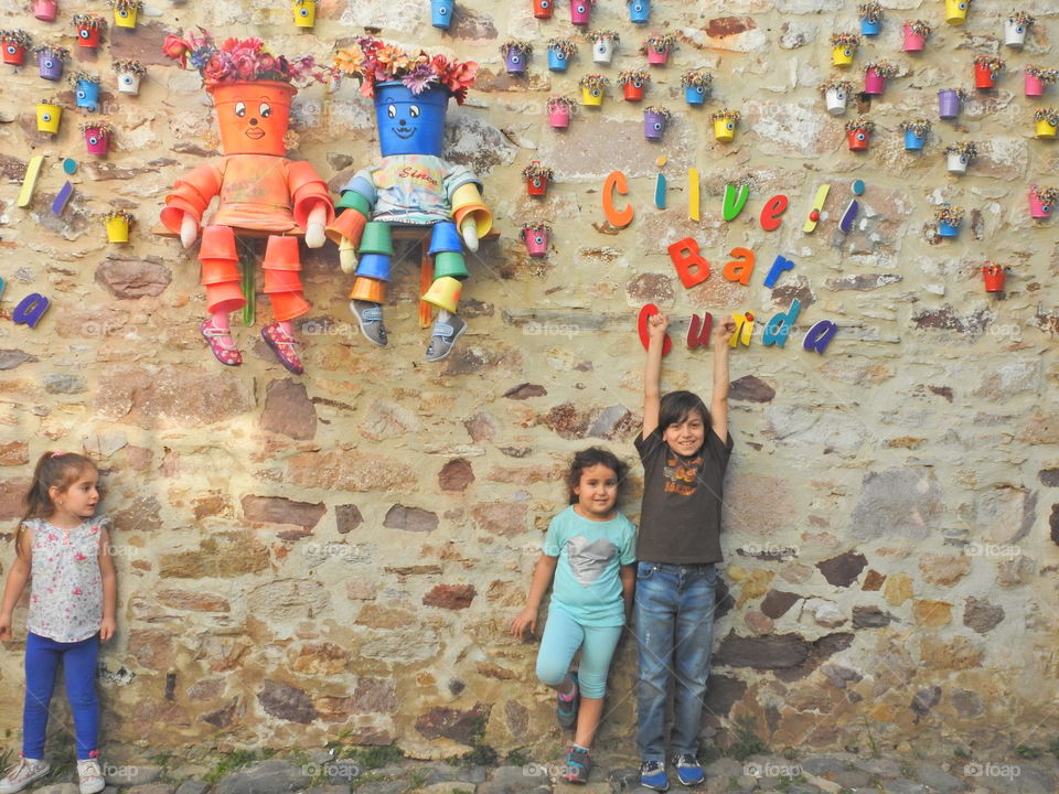 Group of happy children leaning on decorative stone wall