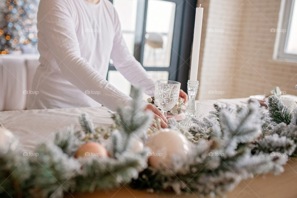 man sets a beautiful decorated winter table for a festive dinner.  Merry Christmas and Happy New Year.