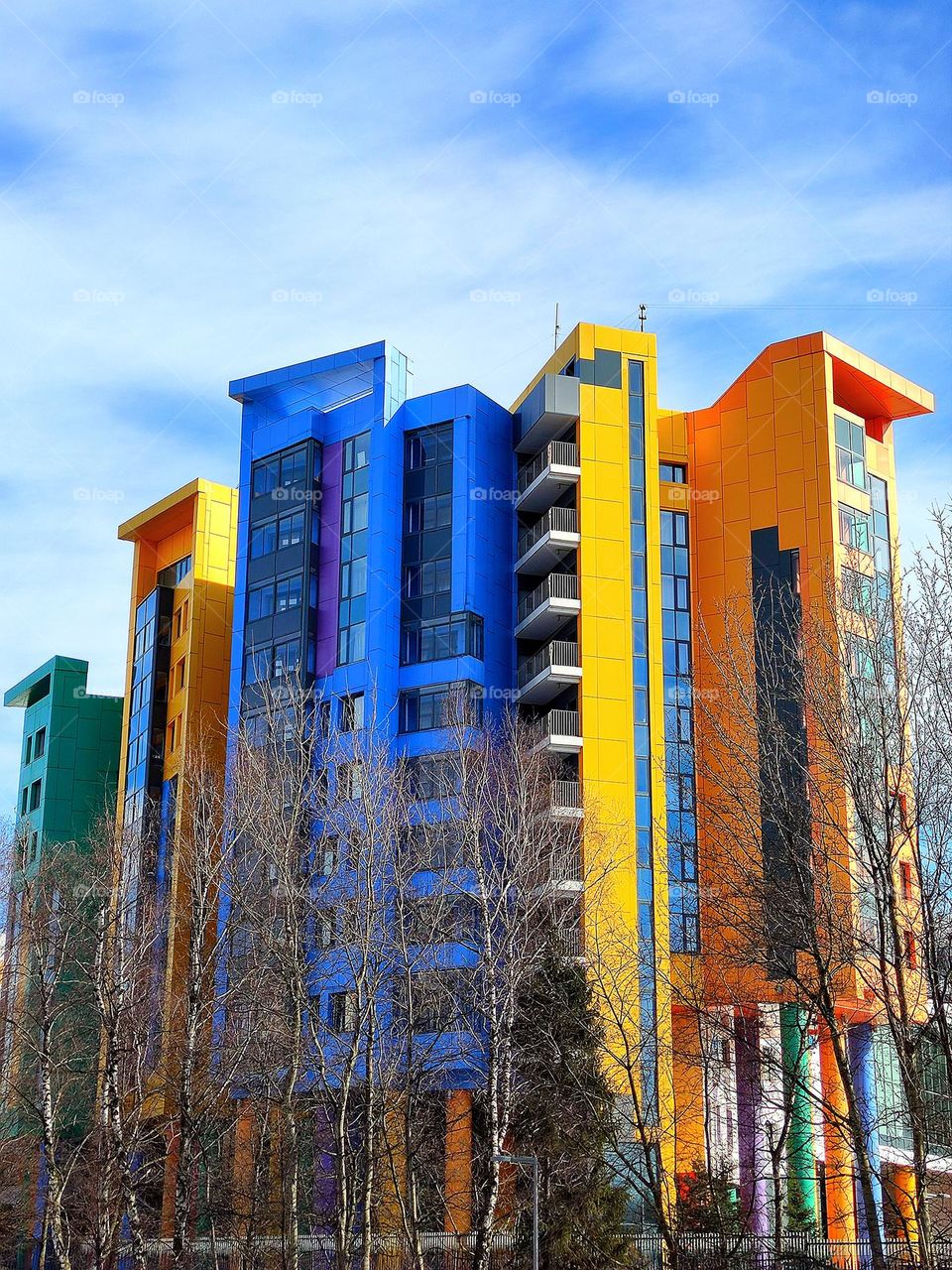 colorful high-rise building against a blue sky with white clouds