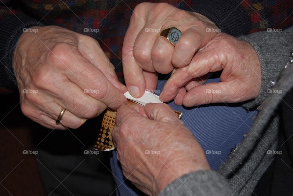 Aging hands unpacking a gift