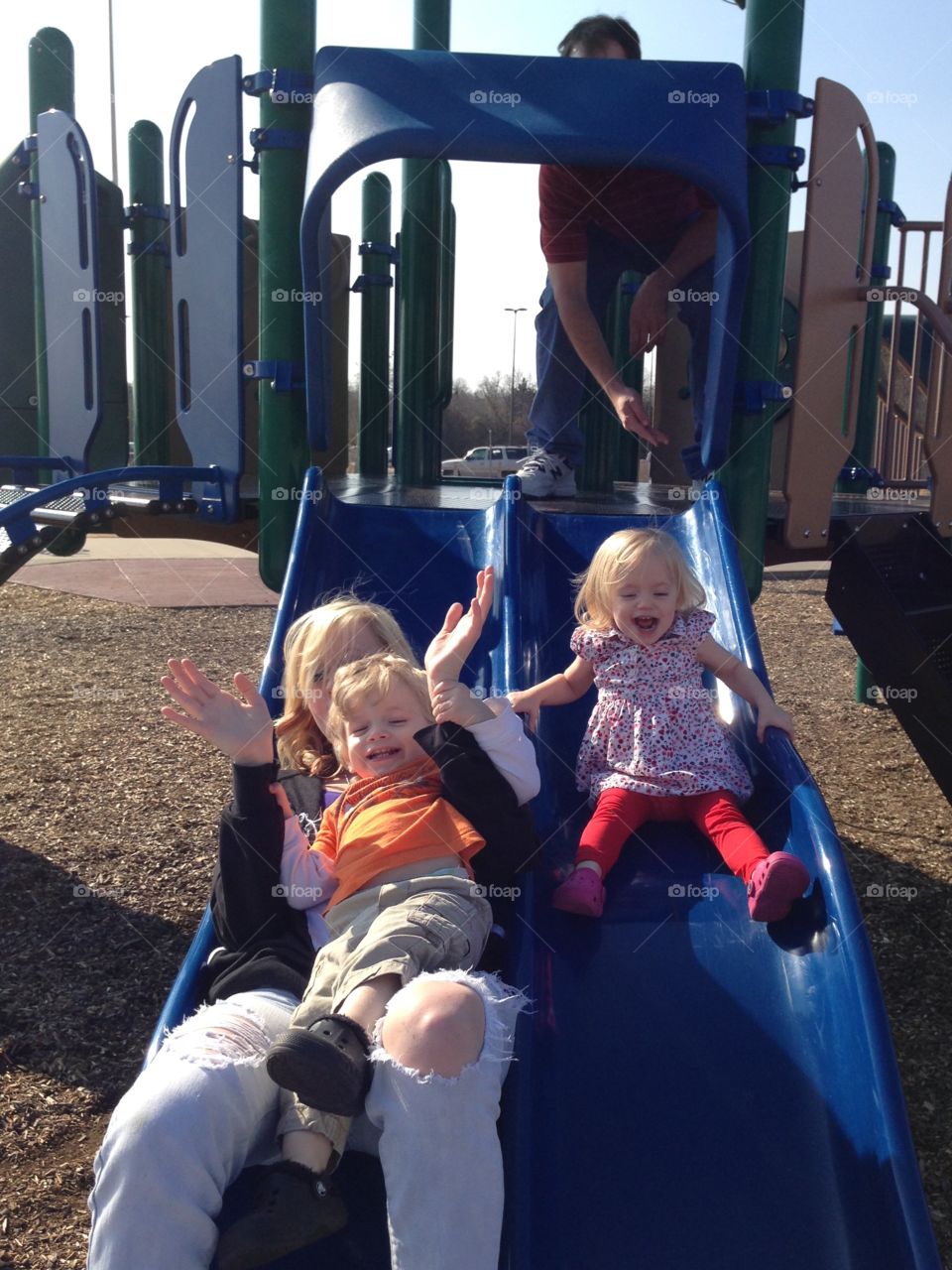 Grown ups on a slide with kids