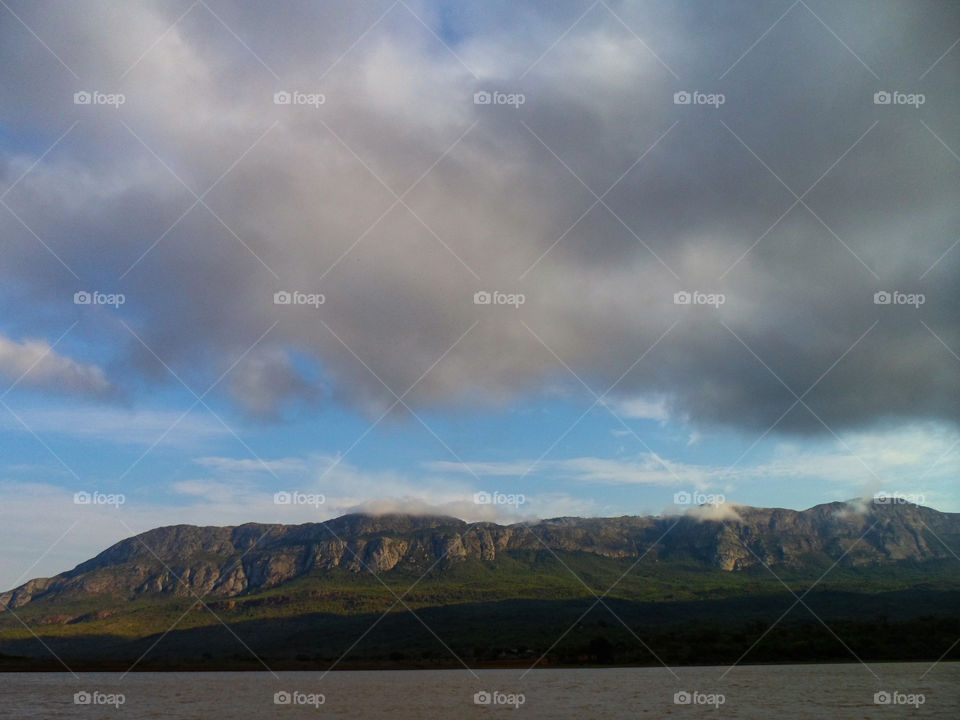 mountain range behind a lake with some cloud cover