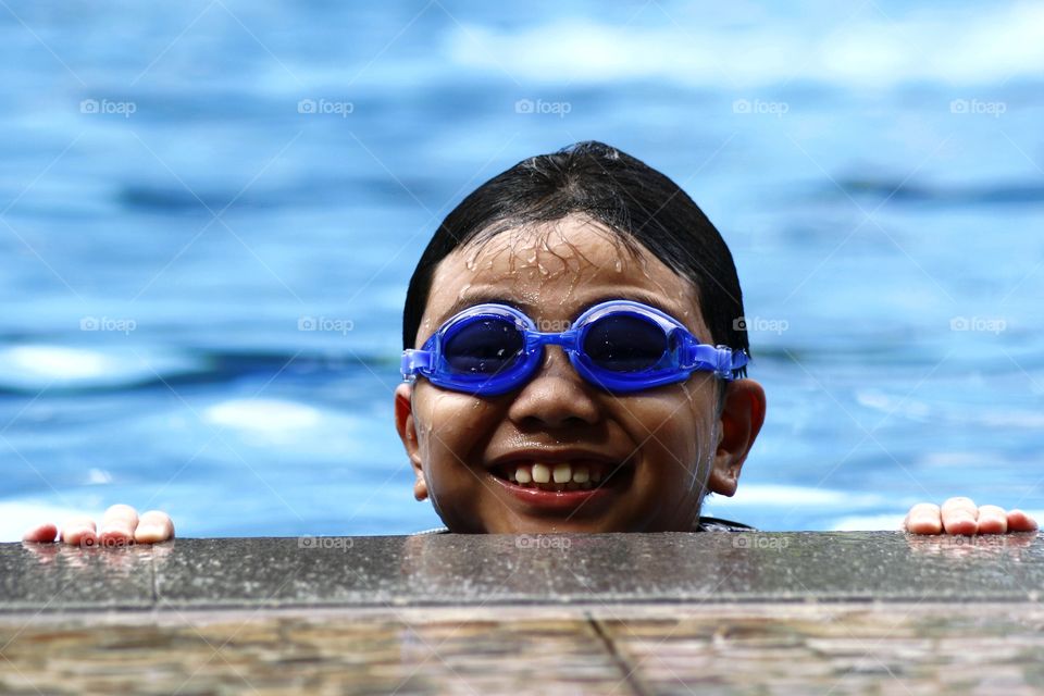 young boy with goggles in a swimming pool