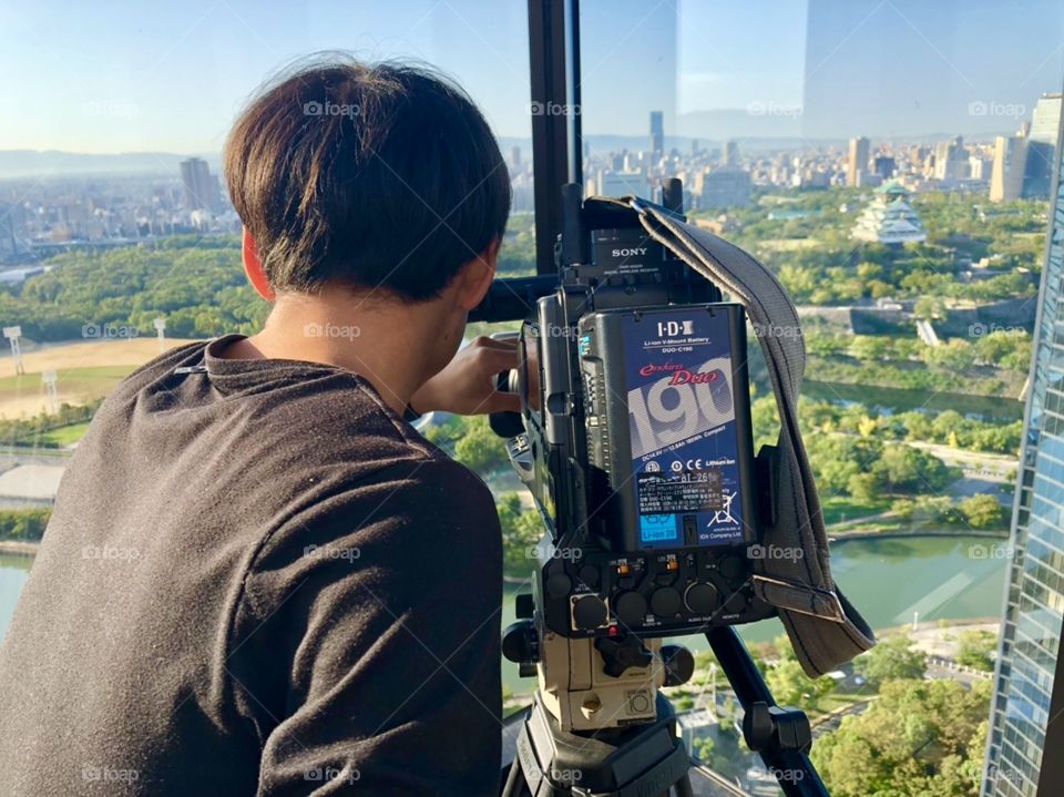 Cameraman filming from the top of skyscraper