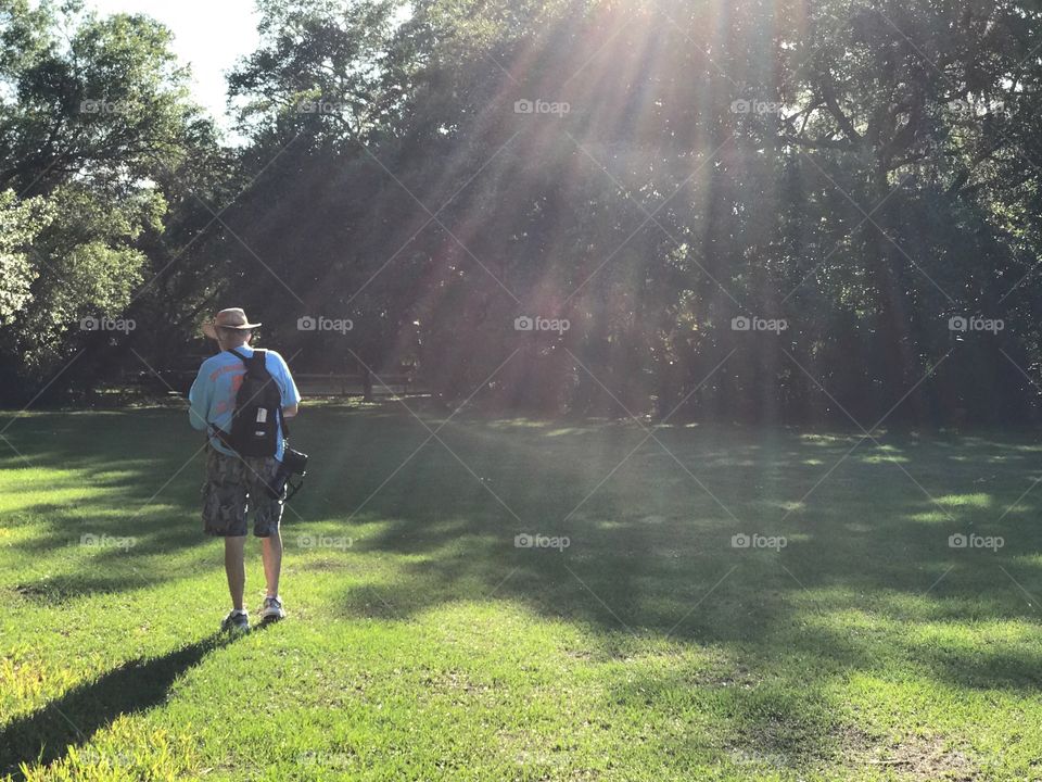 A hiker in rainbow sunshine.