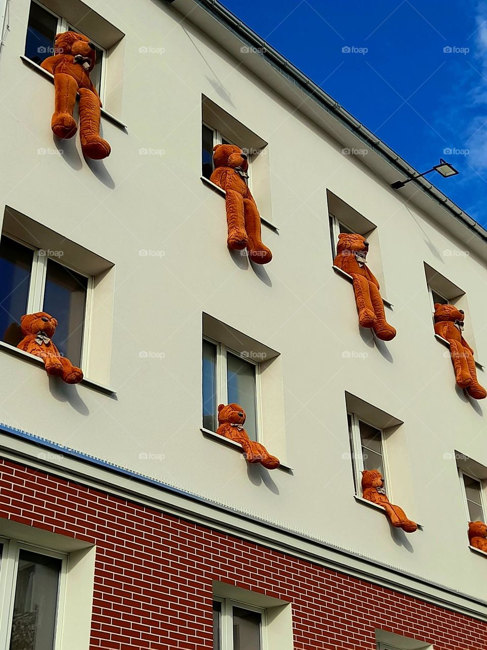 Teddy bears sitting in the windows of the kindergarten
