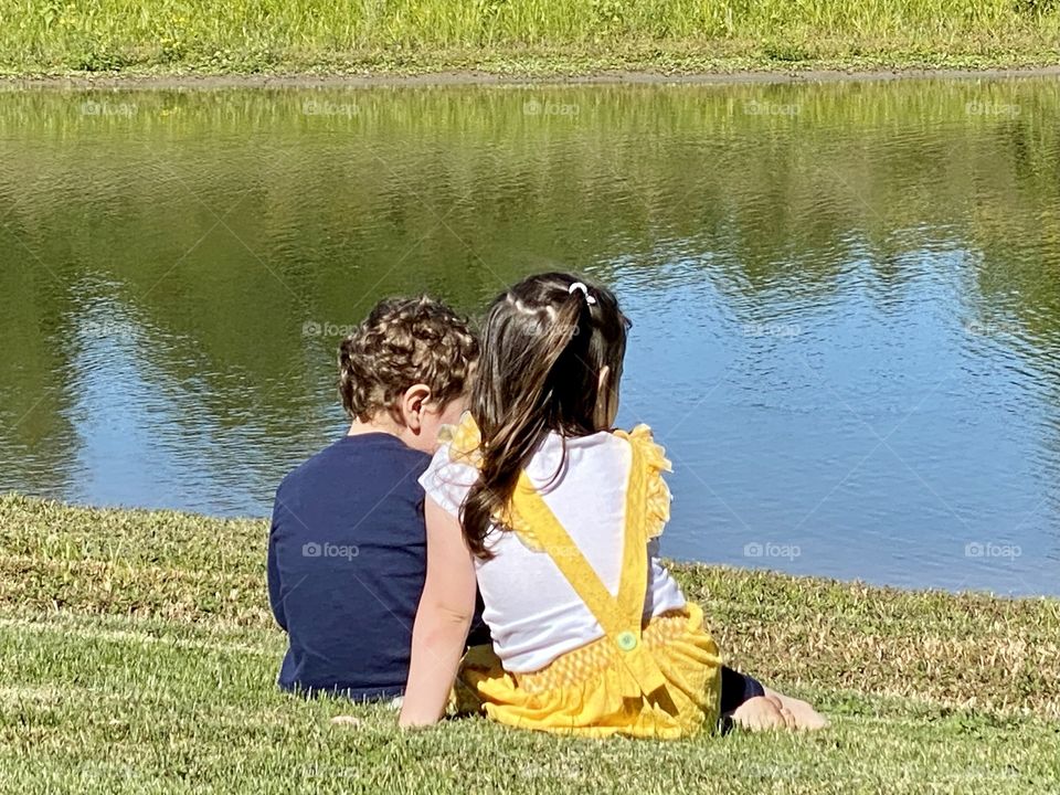 Two toddlers by a pond