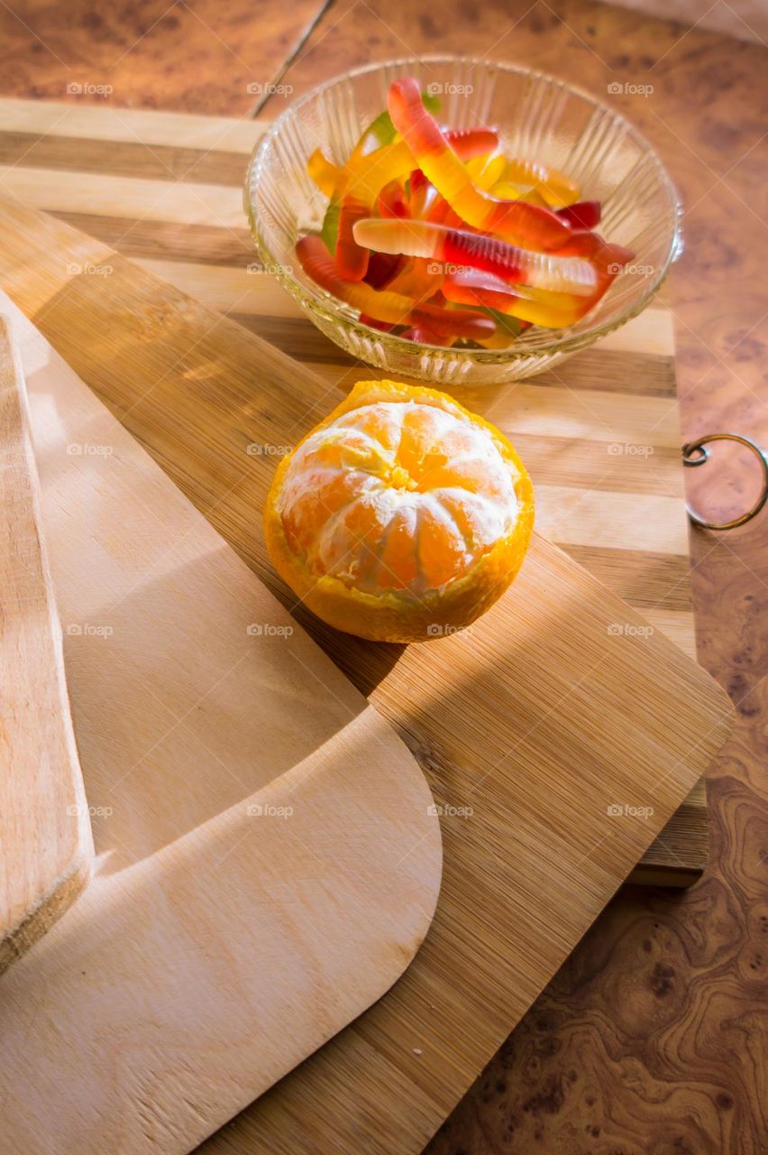 Delicious orange jelly with tangerine slices in a container and jelly worms.