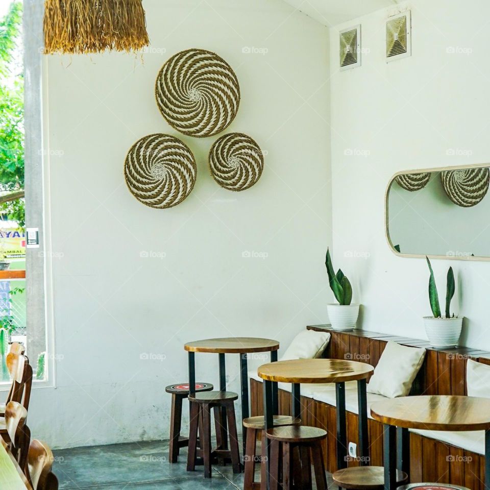 The interior decoration of the cafe includes tables, chairs and wall hangings. Café. Table. Chair. Wood. Circle. Aesthetic. Photography. gathering place. Gather. Place. Decor. Interiors. Scenes.