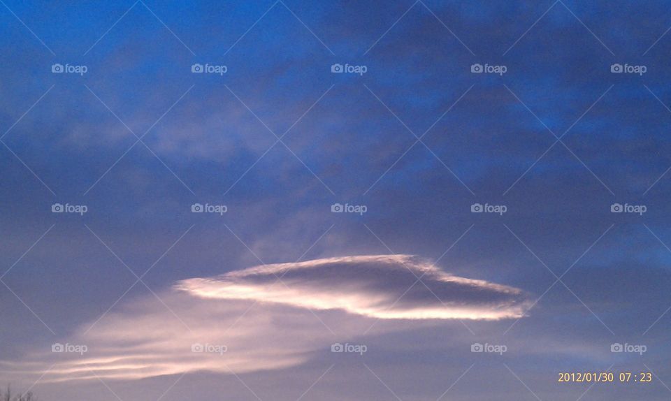 Single cloud sunset. A solitary cloud lights up at sunset