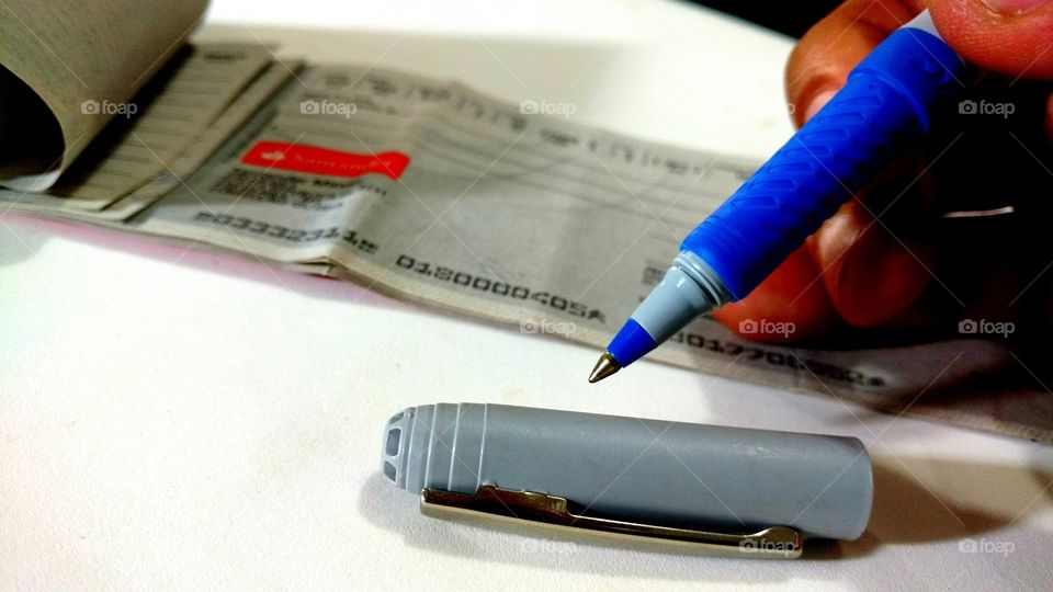 Caneta e talão de cheques.