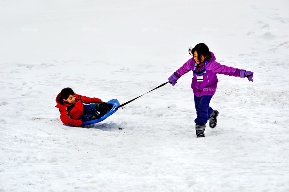 Two children play happily in the snow