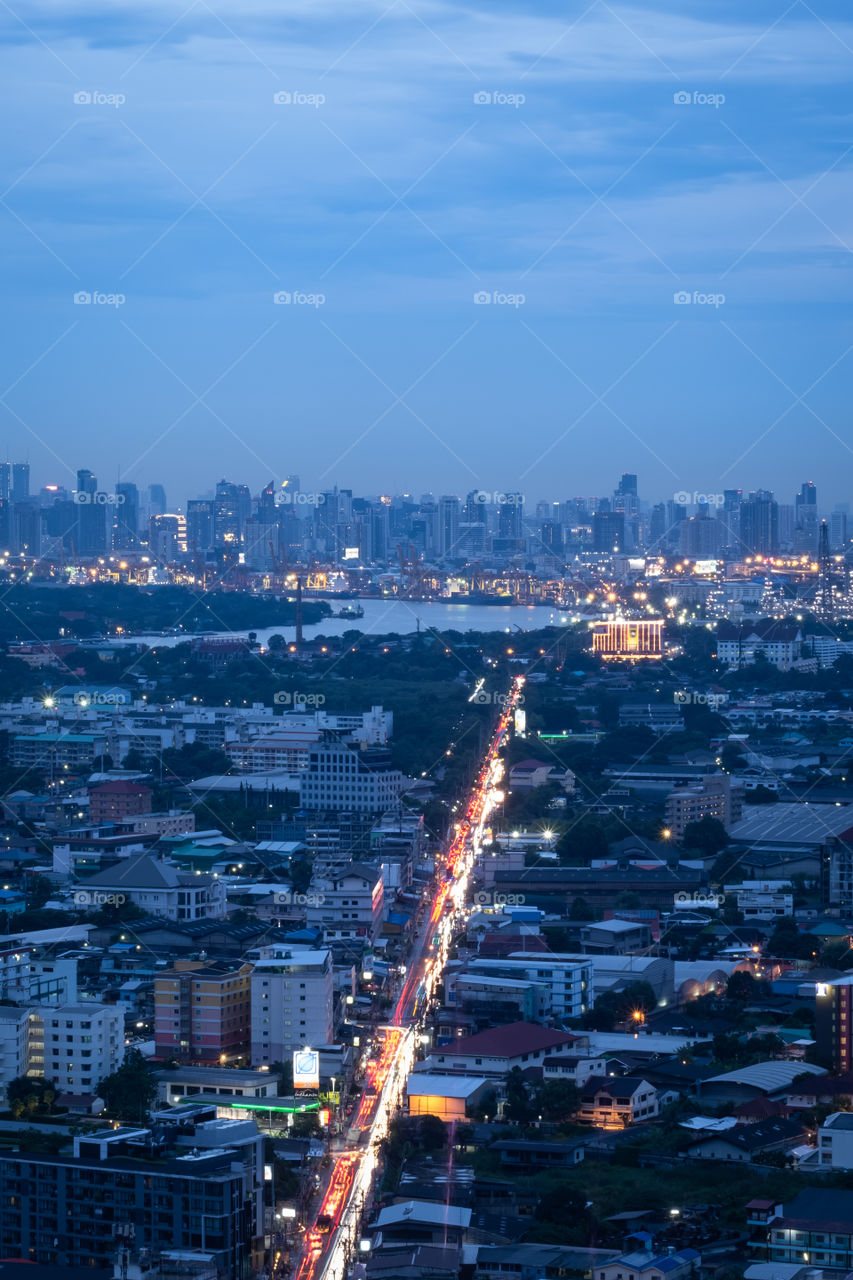 Beautiful movement line of vehicle light on road between building and skyscraper background