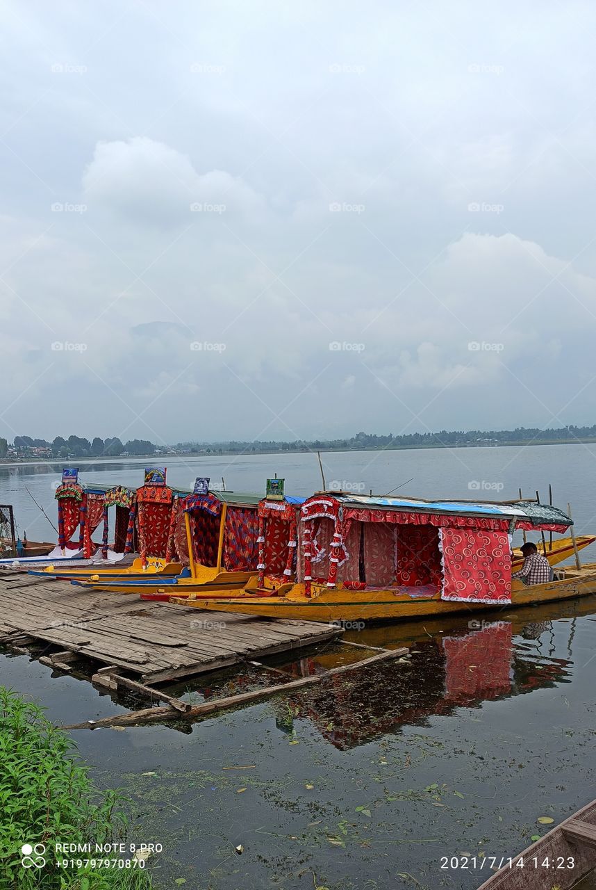 Rowing boats in que waiting for customers in Mis Summer on banks of Dal Lake near Hazeat bhal Shine in Kashmir India