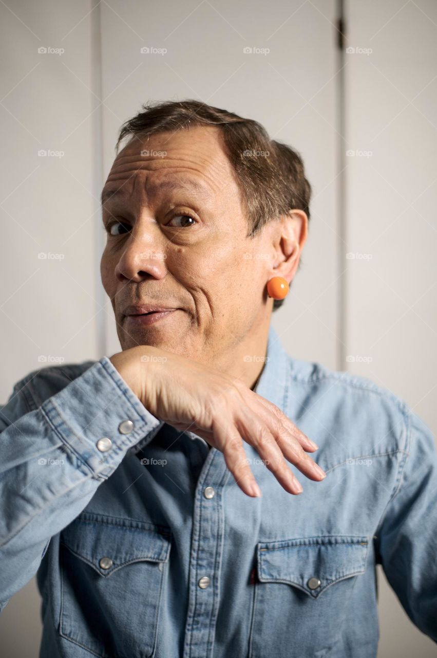 Silly portrait of a man wearing orange earrings 