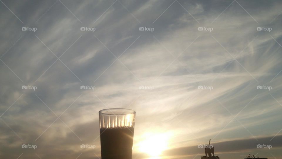 A cup of coffee hugs the sky horizon.