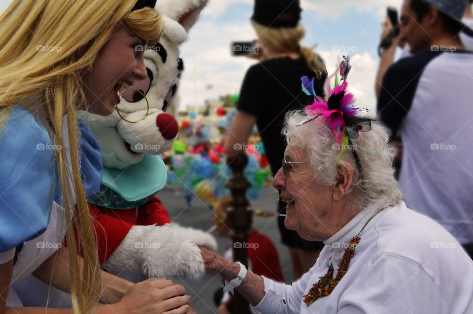 Person in costume hand shaking with senior woman