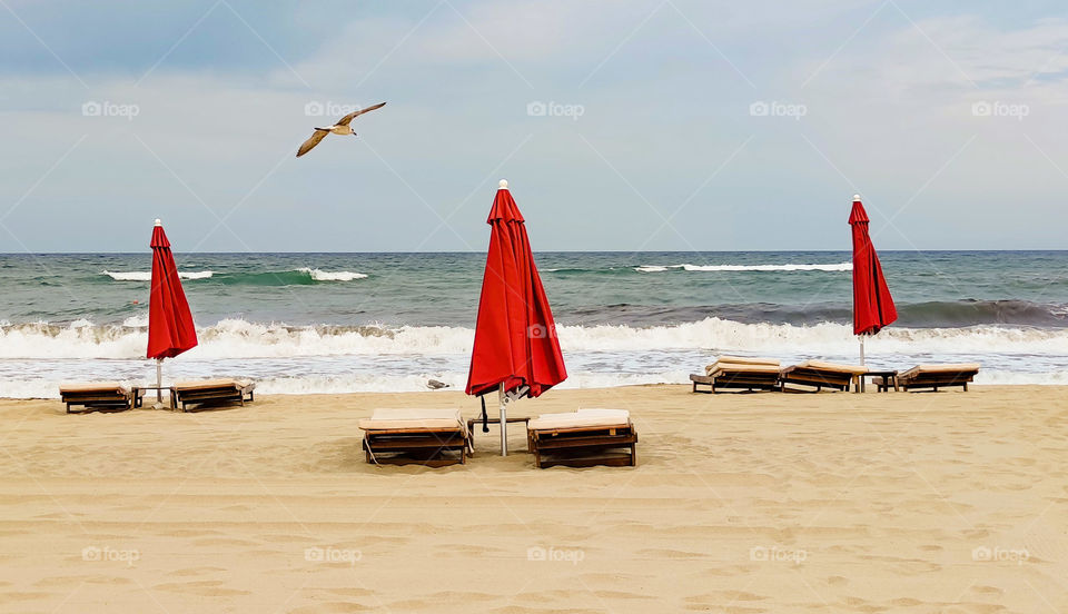 Empty beach with red umbrellas