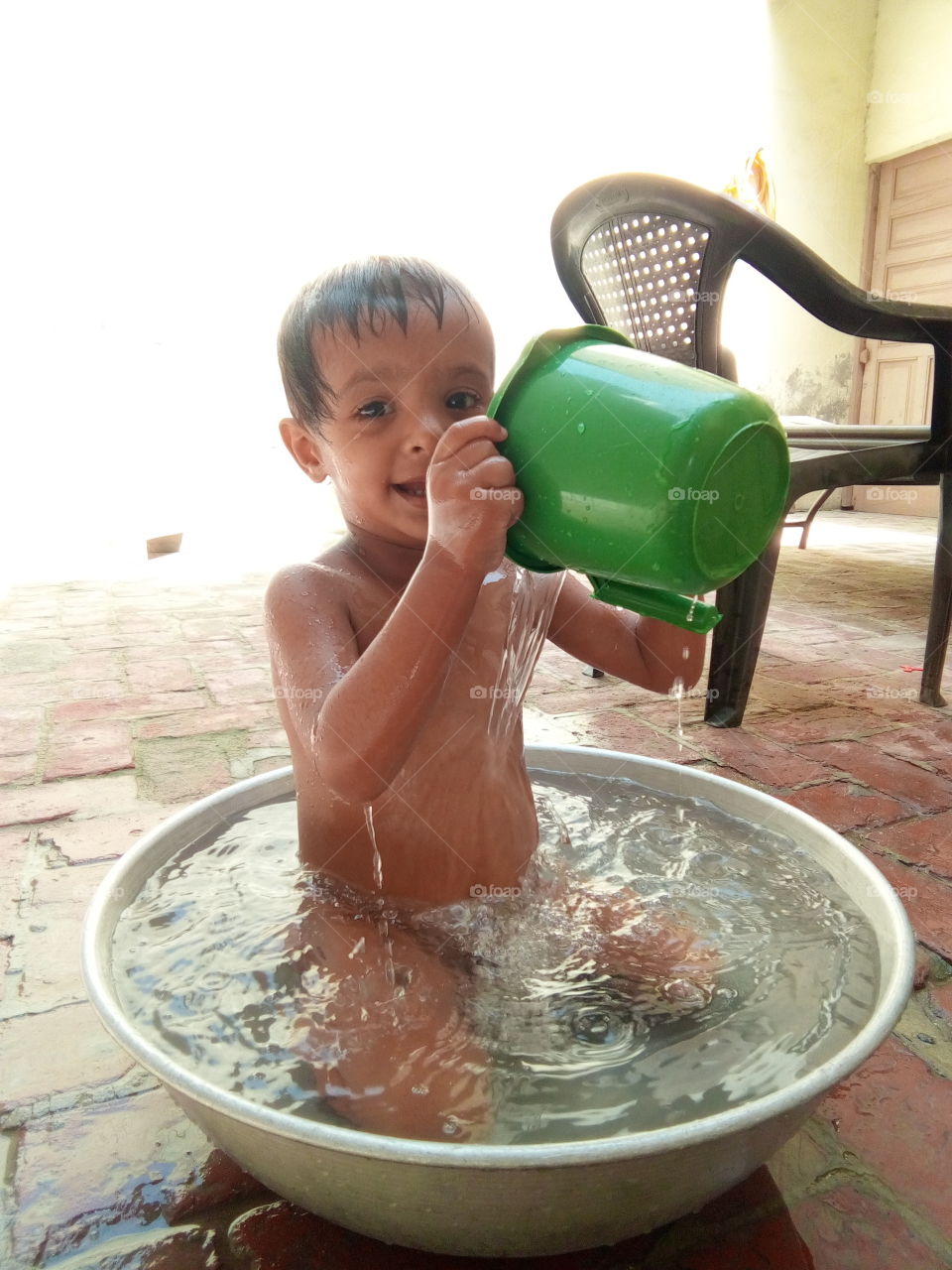 a cute little boy taking bath in a tub.