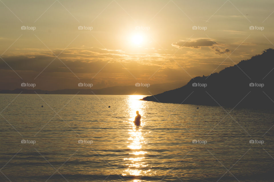 fisherman in sea. fisherman in the sea at sunset