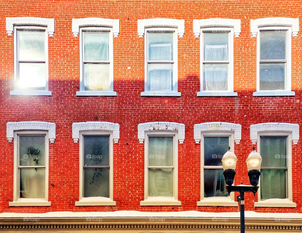 Morning sunlight on windows of a brick building 