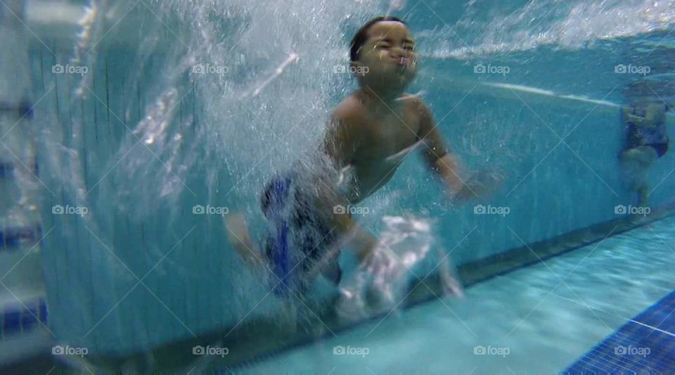 boy doggy paddling underwater