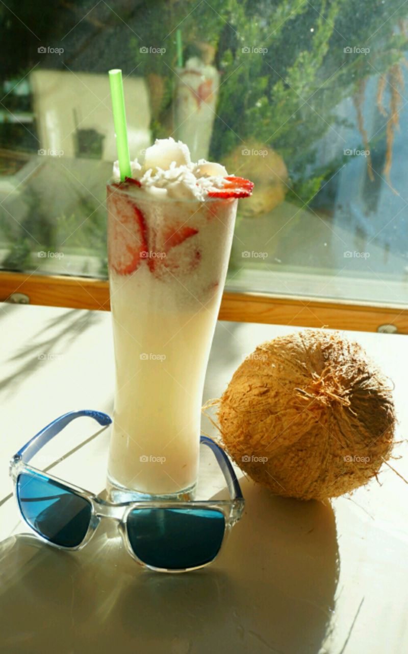 Fresh Fruit smoothie - Young Coconut smoothie topped with slices of strawberries and diced coconut meat