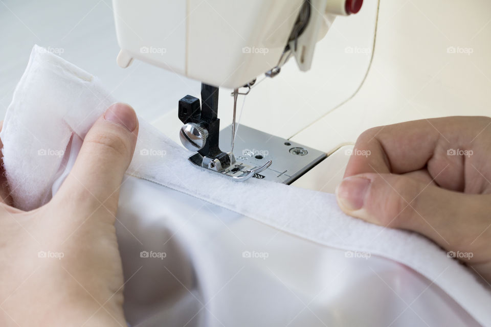 Girl learns to sew on the sewing machine