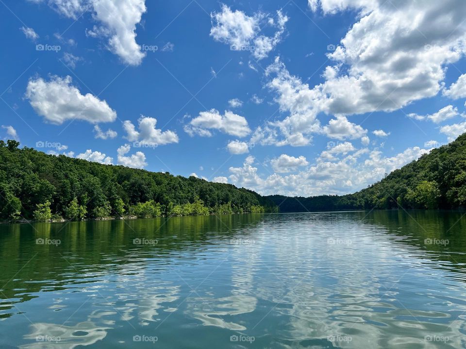 Reflections of the cloud sky on a peaceful bright summer day 