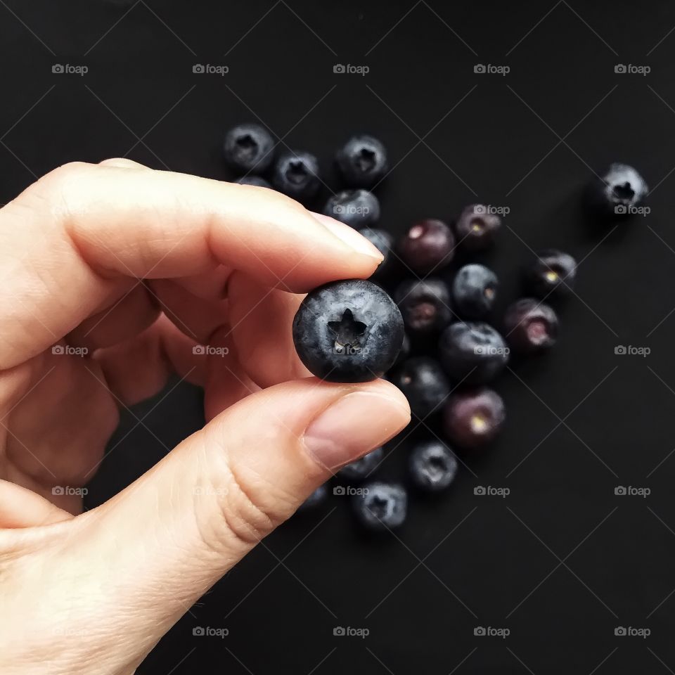 Woman hand holding blueberry