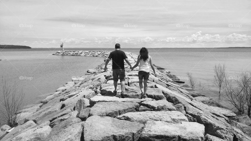 couple walking stone pier