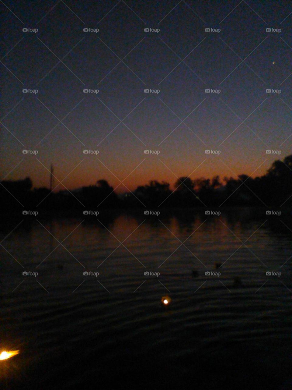 A lake's gentle waves, a sunrise so fine,
A diya's warm glow, like a heartbeat divine.Ripples on the water, a kaleidoscope of hues,A sight so peaceful, it renews and renews.