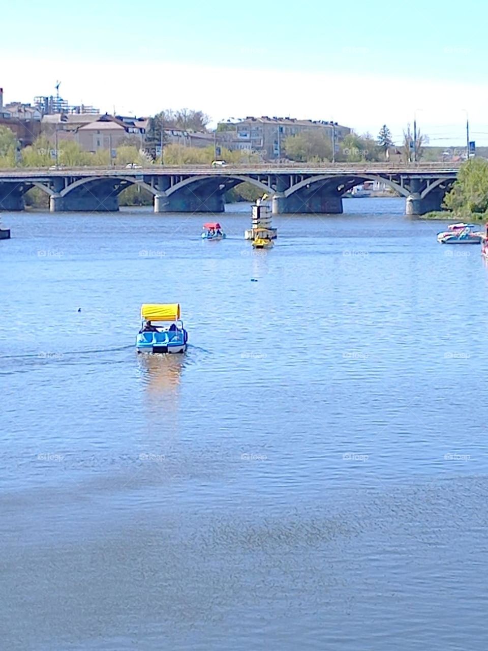 people ride catamarans on the river on a sunny day