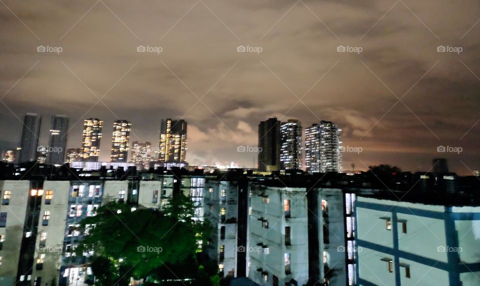 Cityscape 
Night Scene🌃
Illuminated Multistorey Buildings 🏙️
Cloudy Weather ☁️