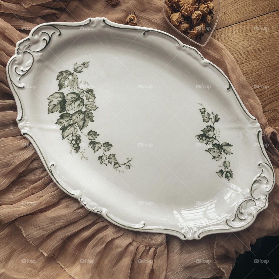 Antique porcelain dish with beauty relief and green grape leaves 